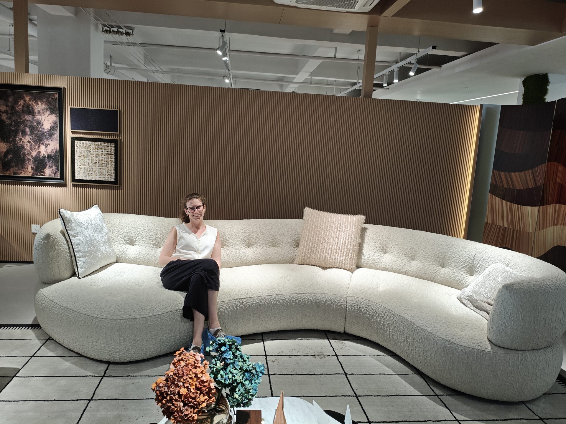 Client reviewing a curved sofa with the Source-From-Foshan team in a Foshan showroom